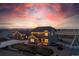 Inviting home featuring a well-manicured lawn, a detached garage, and a colorful sunset in the background at 11343 E 163Rd Ct, Brighton, CO 80602