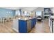 Stylish kitchen with granite countertops, a blue kitchen island, and open layout to dining and living areas at 11343 E 163Rd Ct, Brighton, CO 80602