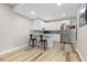 Basement kitchenette with white cabinets, stainless steel appliances, and a bar with seating at 11343 E 163Rd Ct, Brighton, CO 80602