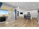 Bright open-concept living room featuring modern lighting, wood floors, and a seamless flow to outdoor patio at 11343 E 163Rd Ct, Brighton, CO 80602