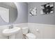 Stylish powder room features updated fixtures, wainscoting, and decorative artwork at 11343 E 163Rd Ct, Brighton, CO 80602