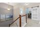 Upstairs landing features wooden staircase, neutral carpeting, and a study with barn door at 11343 E 163Rd Ct, Brighton, CO 80602