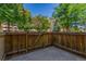 A fenced-in yard is shown with a concrete base and large trees in the background at 6455 E Bates Ave # 4-105, Denver, CO 80222