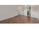 An empty bedroom has hardwood floors, with closets and the entrance to a bathroom at 6455 E Bates Ave # 4-105, Denver, CO 80222