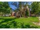 Brick apartment building nestled in lush green landscape with mature trees providing ample shade on a bright sunny day at 6455 E Bates Ave # 4-105, Denver, CO 80222