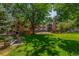 Apartment building exterior featuring a well-manicured lawn and mature trees providing shade and a bench for relaxation at 6455 E Bates Ave # 4-105, Denver, CO 80222