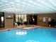 An indoor pool is displayed with large windows and a hot tub in the foreground at 6455 E Bates Ave # 4-105, Denver, CO 80222