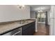 Well-lit kitchen with stainless steel appliances and dark cabinets overlooking the dining area and an outdoor patio at 6455 E Bates Ave # 4-105, Denver, CO 80222