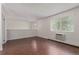 Bright living room featuring wood-look flooring, a large window, and crisp white walls at 6455 E Bates Ave # 4-105, Denver, CO 80222