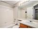 Bright bathroom featuring a shower-tub combination, a large vanity, and a mirrored wall cabinet at 5214 S Tibet St, Aurora, CO 80015