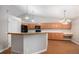 Bright kitchen features light wood cabinets, black appliances, and stylish lighting fixtures over the breakfast bar at 5214 S Tibet St, Aurora, CO 80015