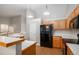 Spacious kitchen offers ample cabinet space, black appliances, and a functional layout for cooking and entertaining at 5214 S Tibet St, Aurora, CO 80015