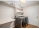 Functional laundry room with modern washer and dryer, shelving, and a convenient folding table at 5214 S Tibet St, Aurora, CO 80015