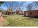 Large backyard with lush lawn, mature trees, pergola and brick structure at 1615 Kearney St, Denver, CO 80220