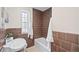 Bathroom featuring brown tiled walls, a tub, and white fixtures at 1615 Kearney St, Denver, CO 80220