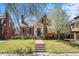 Beautiful brick home featuring a manicured lawn and charming front porch at 1615 Kearney St, Denver, CO 80220
