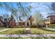 Charming brick home with well-maintained lawn, blooming tree, and welcoming front porch offering classic curb appeal at 1615 Kearney St, Denver, CO 80220