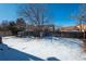 Large backyard with fenced area and a dog house. Partially covered in snow at 4575 Gibraltar St, Denver, CO 80249