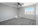 Bright bedroom with grey carpet, ceiling fan, and window offering a view at 4575 Gibraltar St, Denver, CO 80249