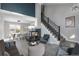 Open concept living room with fireplace, staged furniture, and gray flooring at 4575 Gibraltar St, Denver, CO 80249