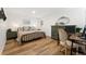 Bright bedroom with hardwood floors, a metal bed frame, and a green dresser with a desk and chair at 34103 Forest Park Dr, Elizabeth, CO 80107