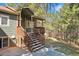 A welcoming wood front porch with steps leads to the entrance of the home, surrounded by trees at 34103 Forest Park Dr, Elizabeth, CO 80107