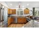 Well-lit kitchen featuring stainless steel appliances, granite countertops, wood cabinets, and wood flooring at 34103 Forest Park Dr, Elizabeth, CO 80107