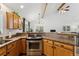 Kitchen featuring stainless steel oven, granite countertops and wood cabinets, flowing into the living area at 34103 Forest Park Dr, Elizabeth, CO 80107