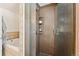 Bathroom showcasing a tiled walk-in shower with a glass door and shelving, adjacent to a tub at 34103 Forest Park Dr, Elizabeth, CO 80107