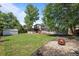 Large backyard featuring a spacious lawn, a covered deck, storage shed, and a cozy fire pit area at 9575 Garland Ct, Westminster, CO 80021