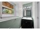 Half bathroom featuring a modern vanity, a well-lit mirror, and a green accent wall adding a touch of nature at 9575 Garland Ct, Westminster, CO 80021