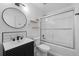 Modern bathroom with updated fixtures, a glass-enclosed shower/tub, and stylish vanity with black and white accents at 9575 Garland Ct, Westminster, CO 80021