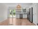 Well-lit kitchen with stainless steel appliances and bright wood floors, perfect for cooking and dining at 9575 Garland Ct, Westminster, CO 80021