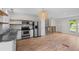 Modern kitchen featuring stainless steel appliances, granite countertops, and stylish open shelving at 9575 Garland Ct, Westminster, CO 80021