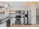 Modern kitchen featuring stainless steel appliances, granite countertops, and bright wood floors at 9575 Garland Ct, Westminster, CO 80021