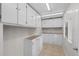 Spacious laundry room featuring ample storage cabinets, countertop workspace, and a utility sink at 9575 Garland Ct, Westminster, CO 80021