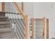 Close up on modern staircase railing with wood and metal elements and carpeted stairs at 9575 Garland Ct, Westminster, CO 80021