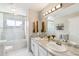 Bright bathroom featuring double vanity, marble floors, and shower-tub combo with glass door at 3612 Rosewalk Cir, Highlands Ranch, CO 80129