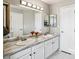 Bright bathroom featuring double vanity, marble countertops, and large mirror at 3612 Rosewalk Cir, Highlands Ranch, CO 80129