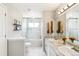 Bright bathroom featuring double vanity, marble floors, and shower-tub combo with glass door at 3612 Rosewalk Cir, Highlands Ranch, CO 80129