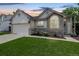 Charming single-Gathering home with stone accents, lush lawn, and attached two-car garage at 3612 Rosewalk Cir, Highlands Ranch, CO 80129