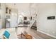 Bright, open living room with wood floors that flows to the kitchen, with stairs to the upper level at 3612 Rosewalk Cir, Highlands Ranch, CO 80129