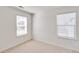Bedroom features neutral carpet, two windows, and an electrical outlet at 18120 Dandy Brush Ln, Parker, CO 80134