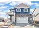 Charming two-story home with blue siding, stone accents, a covered porch, and a two-car garage at 18120 Dandy Brush Ln, Parker, CO 80134