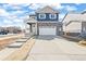 Charming two-story home with blue siding, stone accents, a covered porch, and a two-car garage at 18120 Dandy Brush Ln, Parker, CO 80134