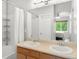 Bright bathroom featuring a double sink vanity, shower with curtain, and neutral tones at 12973 Grant E Cir # A, Thornton, CO 80241
