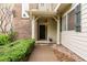Front entry with covered porch and walkway with a small garden at 12973 Grant E Cir # A, Thornton, CO 80241