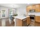Open kitchen with eat in island, stainless steel appliances, and an adjacent dining area at 12973 Grant E Cir # A, Thornton, CO 80241
