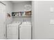 Practical laundry room with a washer, dryer, and storage shelves at 12973 Grant E Cir # A, Thornton, CO 80241
