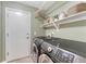 Practical laundry room equipped with modern washer and dryer, and ample shelving at 22056 E Jamison Pl, Aurora, CO 80016